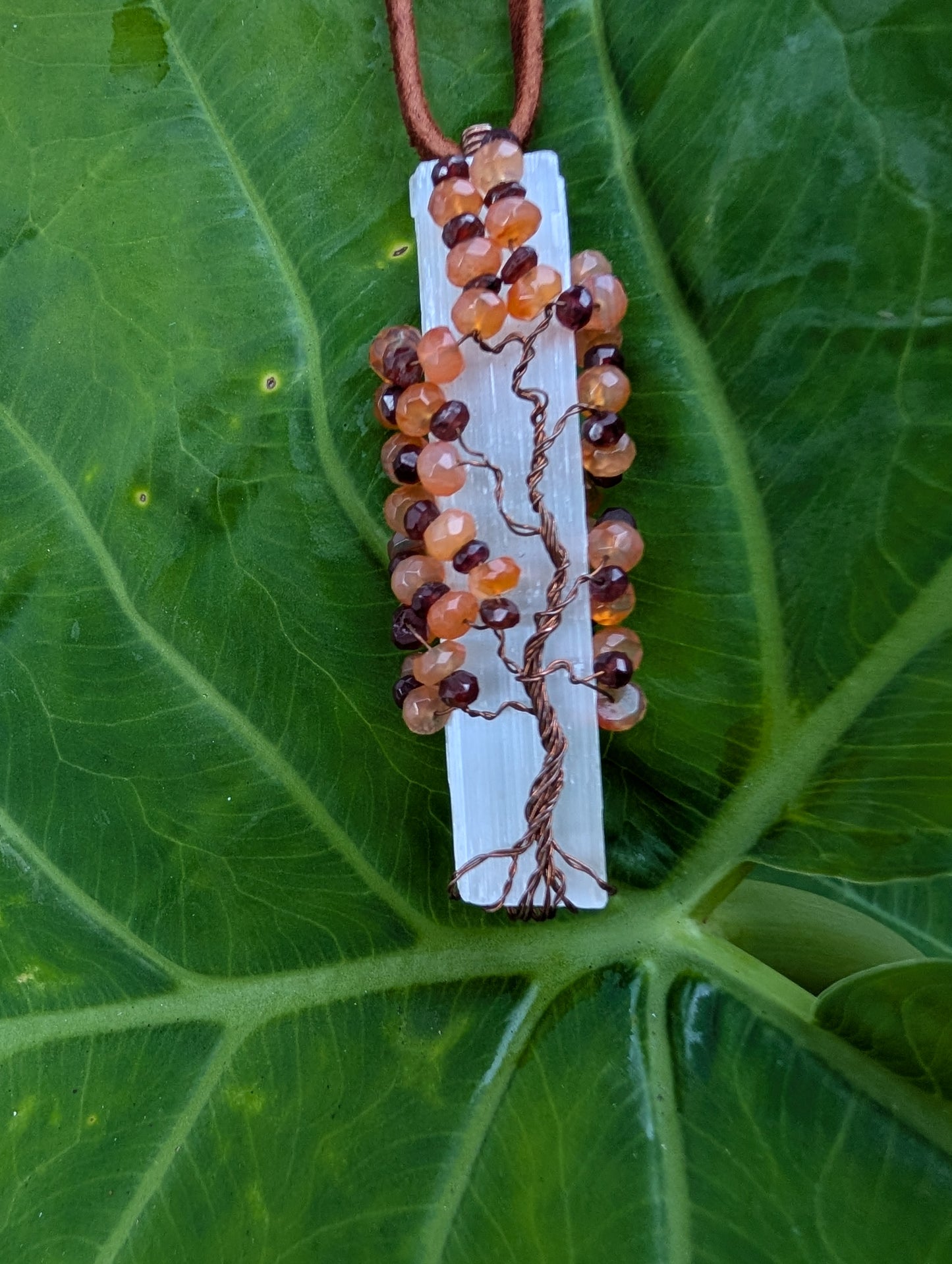 Lovely Tree of Life wire wrapped on selenite with carnelian and garnet. Comes On leather cord. Handmade. Wire wraps.