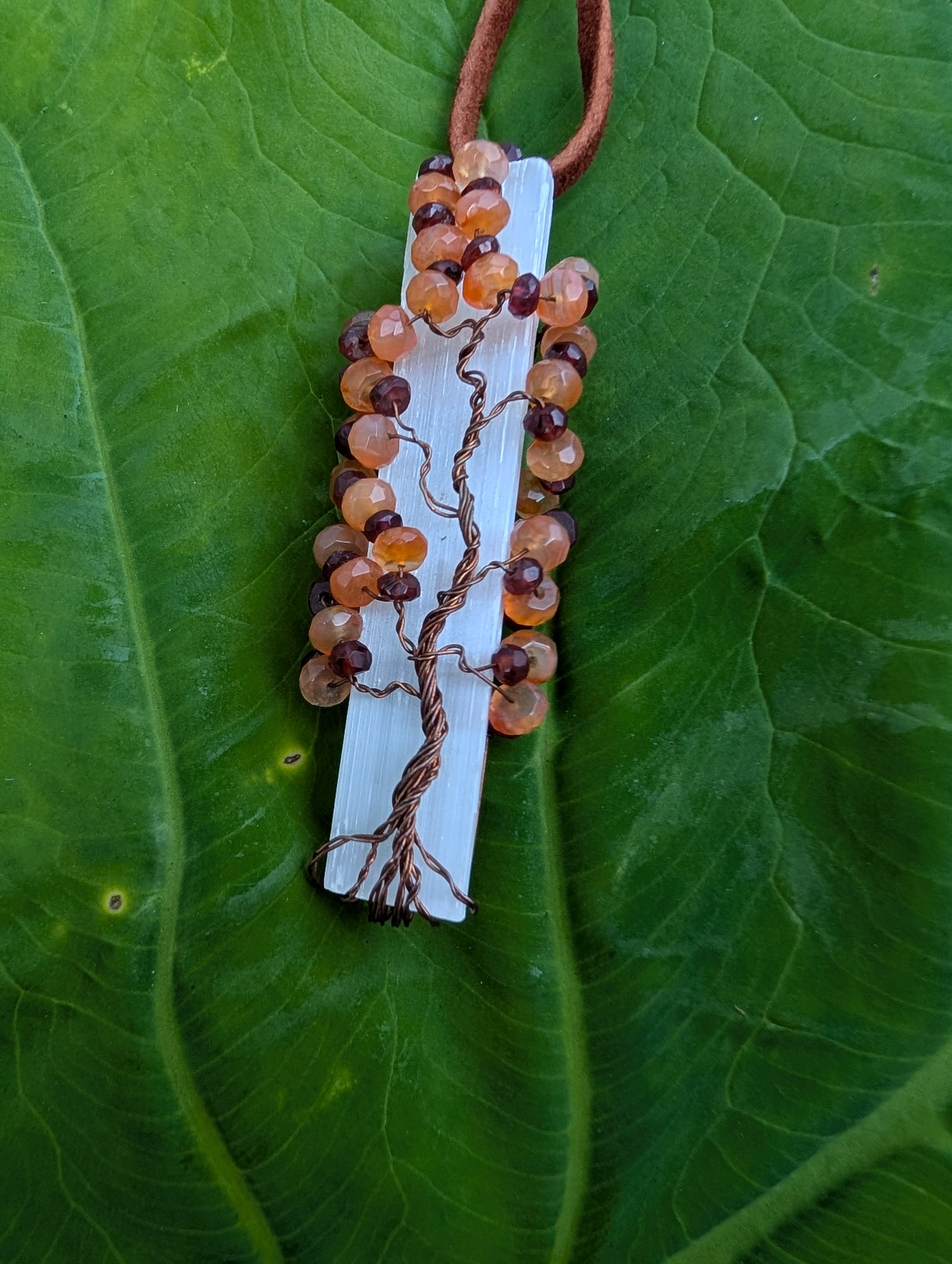 Lovely Tree of Life wire wrapped on selenite with carnelian and garnet. Comes On leather cord. Handmade. Wire wraps.