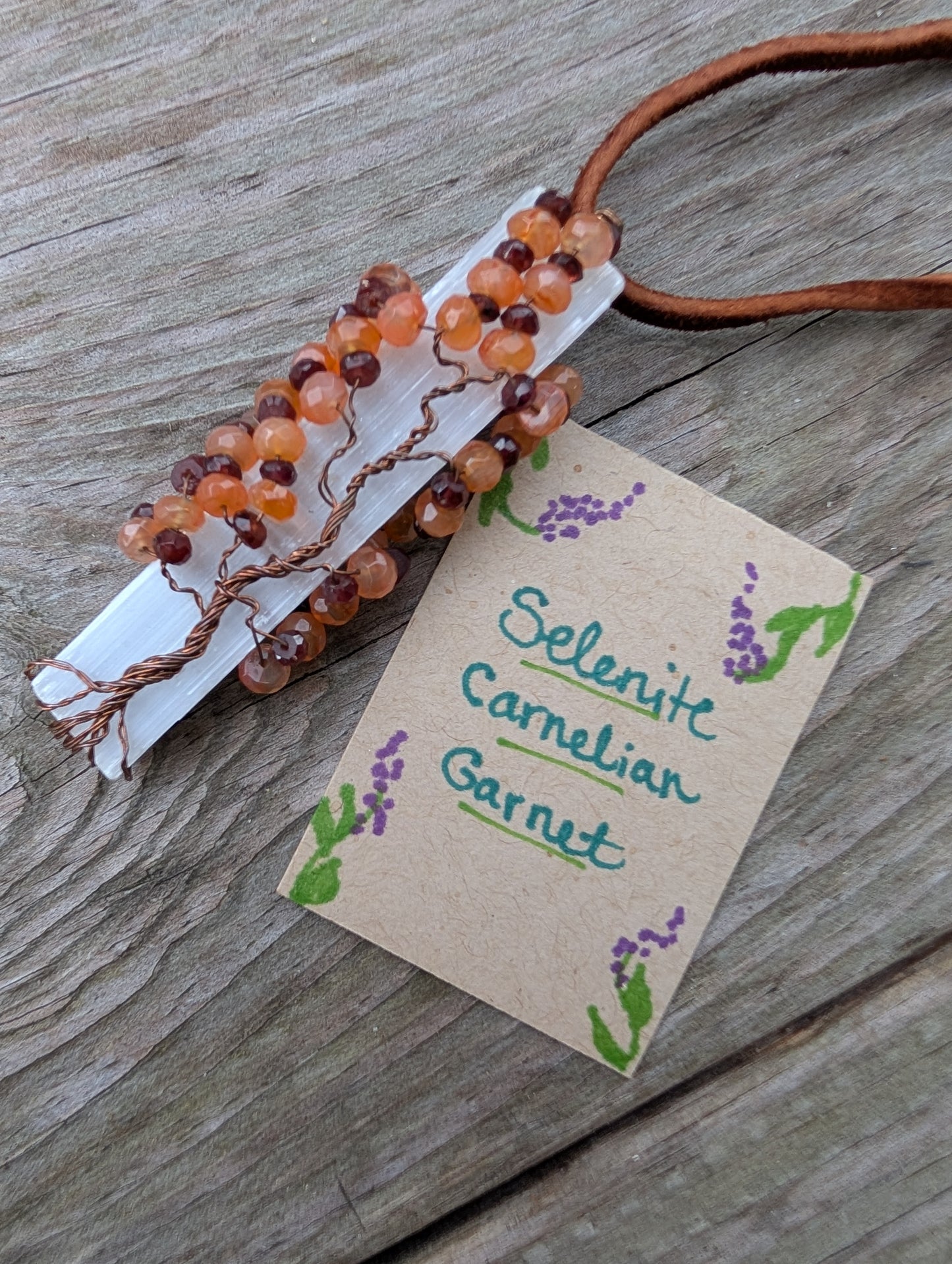 Lovely Tree of Life wire wrapped on selenite with carnelian and garnet. Comes On leather cord. Handmade. Wire wraps.
