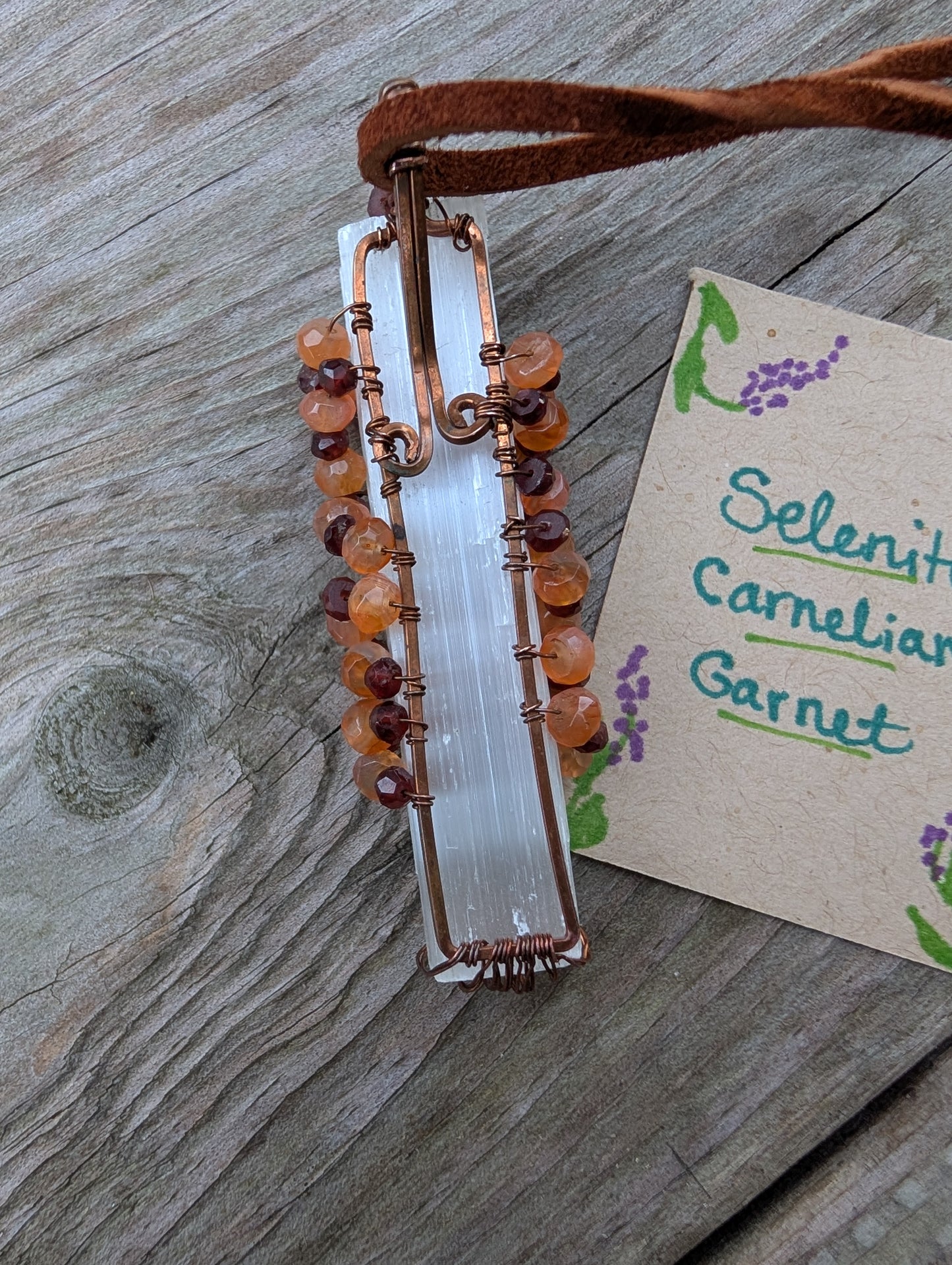 Lovely Tree of Life wire wrapped on selenite with carnelian and garnet. Comes On leather cord. Handmade. Wire wraps.