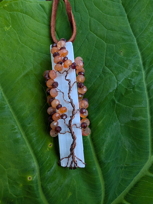 Lovely Tree of Life wire wrapped  on selenite with carnelian and garnet. Comes On leather cord.  Handmade. Wire wraps.
